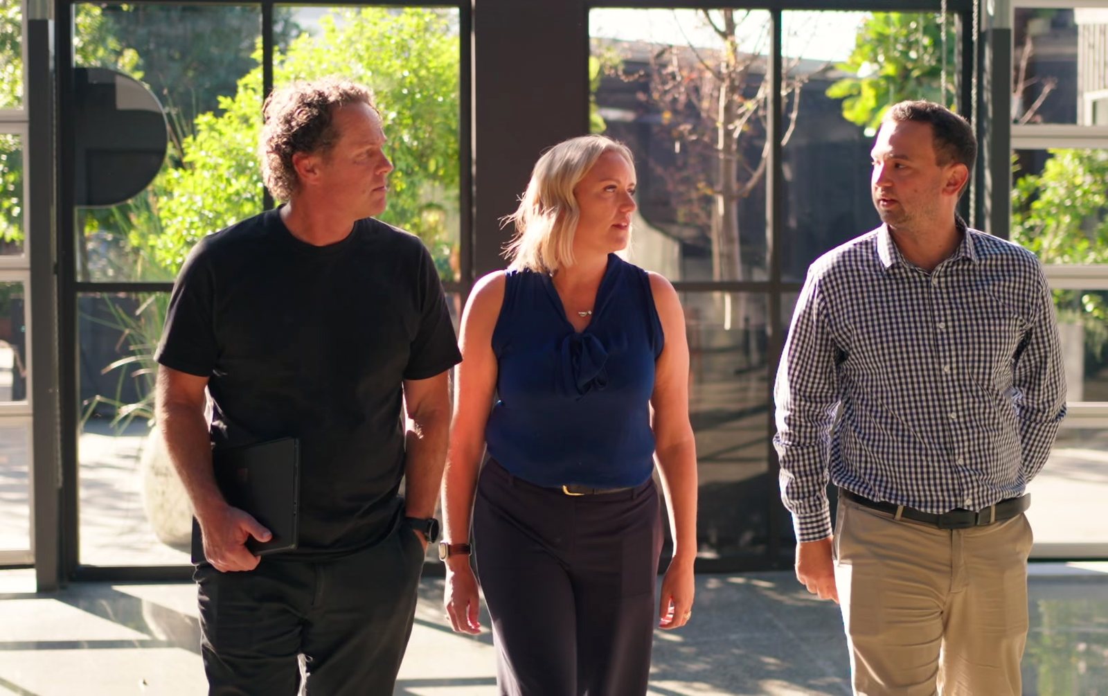 Matt, Mell and a client walking out through a glass atrium